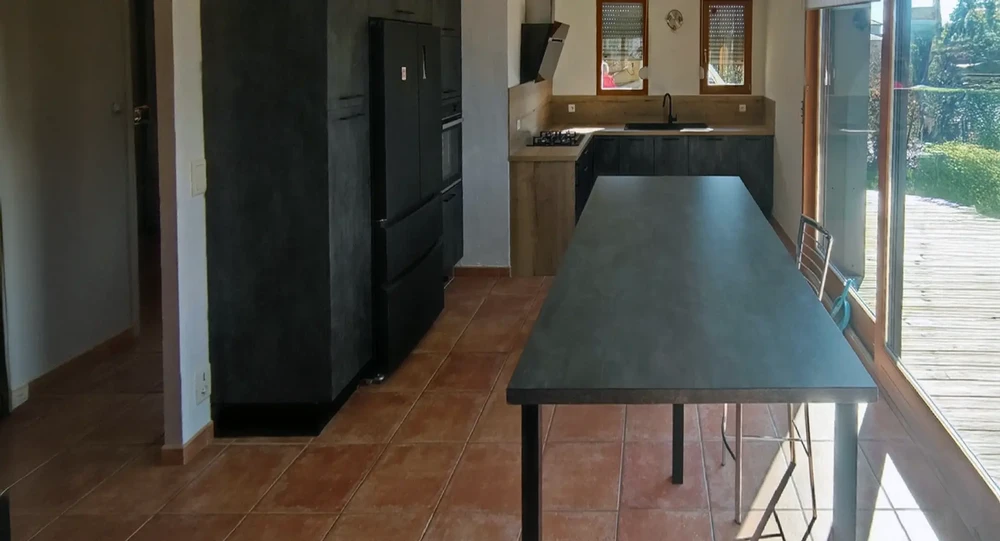 Cuisine moderne avec îlot central et mobilier contemporain dans un espace ouvert donnant sur terrasse bois