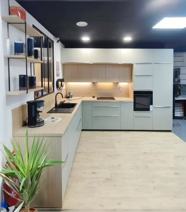 Salon moderne lumineux avec canapé sectionnel blanc, cuisine ouverte avec îlot et tabourets en bois